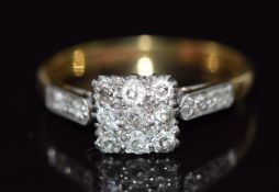 An 18ct gold ring set with nine diamonds in a square platinum setting with further diamonds to the