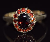 A 9ct gold ring set with garnets in an oval cluster, 2.5g, size O