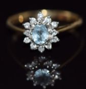 A 9ct gold ring set with an oval cut aquamarine surrounded by diamonds, 2.2g, size O