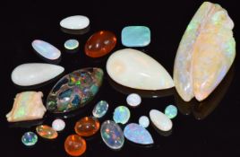 A carved opal in the form of a man, two pearl cut loose opals, three loose fire opal cabochons,