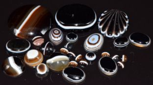 A collection of banded agate cabochons and a carved banded agate cabochon in the form of a shell
