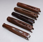 Five Beretta or similar chequered shotgun forends, one with metal fittings.