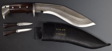 Large Kukri in scabbard and two smaller examples