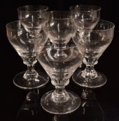 A set of six clear glass rummers raised on waisted stems, 14.5cm tall.