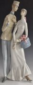 Lladro figure of a girl with a hatbox talking to a bellboy, H44cm