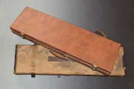 Two vintage shotgun cases, one canvas and leather the other leather style, both with fitted