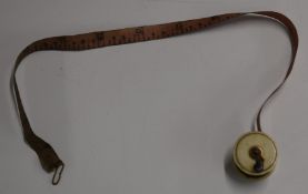 Novelty bone and brass sewing tape measure formed as a fishing reel, diameter 2.8cm