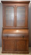 A 19thC oak bureau bookcase with adjustable dog tooth shelving and roll front opening, W118 x D55