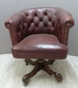 A vintage leather Chesterfield swivel / office chair with button back and wooden base, H87cm
