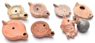 Seven Roman / Roman style terracotta oil lamps, length of longest 13cm and a Roman vase