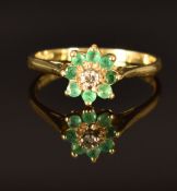 An 18ct gold ring set with a diamond and emeralds, size S/T, 3.6g