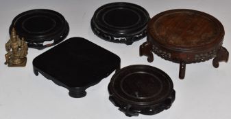 Four Chinese wooden stands and a bronze deity, largest stand diameter 17cm