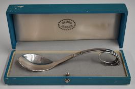 Cased Georg Jensen hallmarked silver jam spoon with hammered decoration to bowl and looping