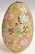A continental gilt and cloisonné enamel egg with stylised foliage and geometric motifs on a matt