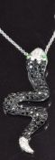 A 14k white gold pendant in the form of a snake set with diamonds, black diamonds and demantoid