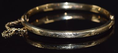 A 9ct gold bangle with engraved decoration, 7.3g
