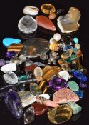 A collection of loose gemstones including tiger's eye, topaz, turquoise, rutile quartz, garnet,