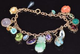 A 9ct gold charm bracelet with 16 charms including amethyst, jade, opal, zircon, coral, peridot,