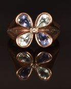 A 9k rose gold ring set with aquamarine, iolite and a white sapphire in a flower setting, size L/