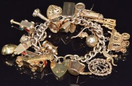 A 9ct gold charm bracelet with twenty four 9ct gold charms including speed boat, shark, golf