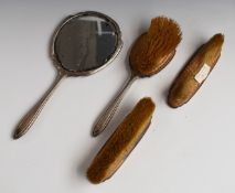 Hallmarked silver backed dressing table set comprising hand mirror and three brushes