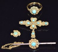 A yellow metal ring set with a turquoise cabochon surrounded by filigree, with two matching