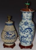 Two Chinese porcelain table lamps, one decorated with serpents, the other reticulated, H63cm and