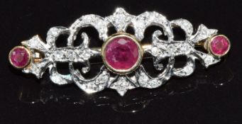 A 9ct gold brooch set with three round cut rubies and diamonds, 4.2g