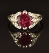 A platinum ring set with a round cut ruby and with diamonds to the shoulders, size K/L, 6.9g
