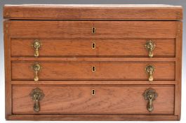 An oak collector's chest with three drawers and lift up flap, the bottom and top drawers with lift