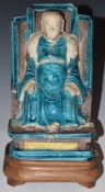Chinese 19thC figure of a Mandarin seated on a throne, part polychrome decorated, raised on a wooden