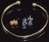 A 9ct gold bangle, a pair of 9ct white earrings and a pair of 9ct gold earrings set with a diamond
