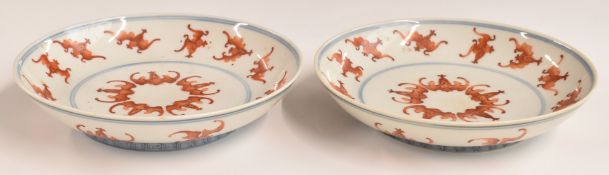 A pair of Chinese iron red and blue dishes decorated with bats, six character Guangxu marks to