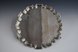 Edward VII hallmarked silver salver with shaped edge, raised on three scroll feet, London 1909,