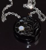 A carved black coral pendant depicting a shark, with flower set with a star sapphire verso, 3.5cm