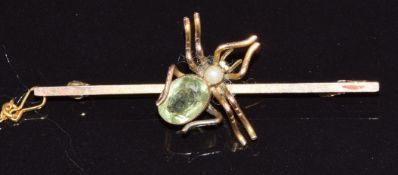 A 9ct gold brooch set with peridot and a faux pearl in the form of a spider, 3.1g