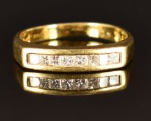 An 18ct gold ring set with eight princess cut diamonds, size J, 2.7g