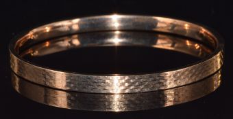 A 9ct gold flapper bangle with engine turned decoration, 9.7g