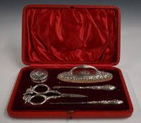 Cased Edward VII hallmarked silver mounted manicure set with embossed cherub decoration,