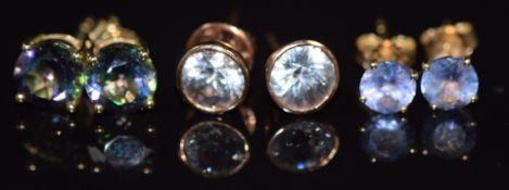 Three pairs of 9k gold earrings, one pair set with tanzanites, one with zircons and the other mystic