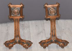 A pair of continental bronze fire dogs with portrait and fleur de lys decoration, H39cm