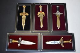 A set of eight dragon themed knives on purpose made plaques by Michael Whelan, including Vengeance