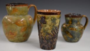 Two Royal Doulton Foliage Ware jugs and a beaker decorated in the Autumn Leaves pattern, including a