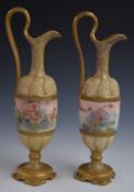 A pair of c1900 Royal Doulton pedestal ewers hand decorated with flowers, H 35cm