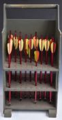 A collection of vintage archery arrows in wooden stand