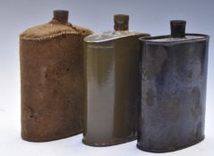 British WW1 water bottles, one with cover, together with a similar example