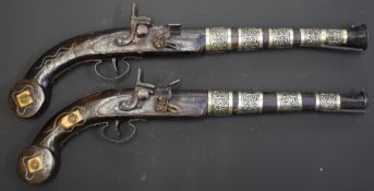 A pair of flintlock pistols each with inlaid and bone and wire decoration, white metal barrel