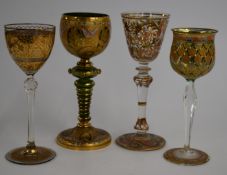 Four gilt hand decorated wine glasses including a signed example, tallest 21cm