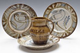 Wenford Bridge Pottery advertising jug and three studio pottery chargers with impressed tree and