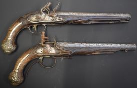 A pair of unnamed flintlock pistols each with wire inlaid grip, heavily cast butt cap, engraved